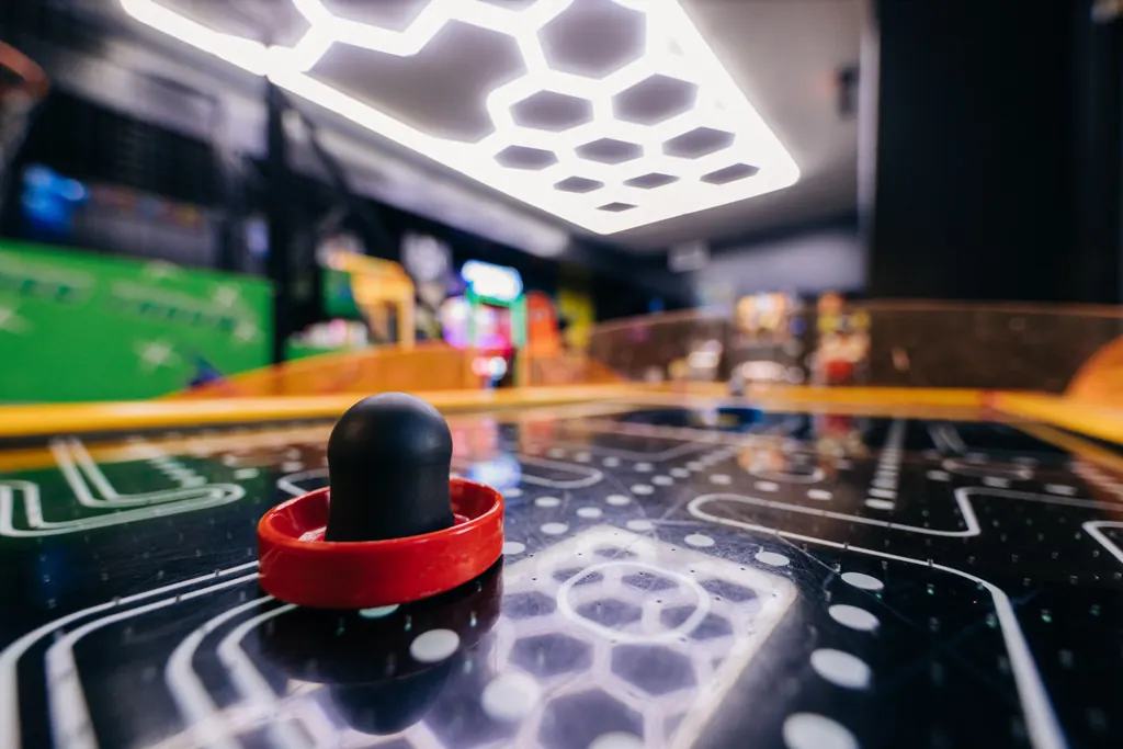 Air hockey table glowing under the game room lights