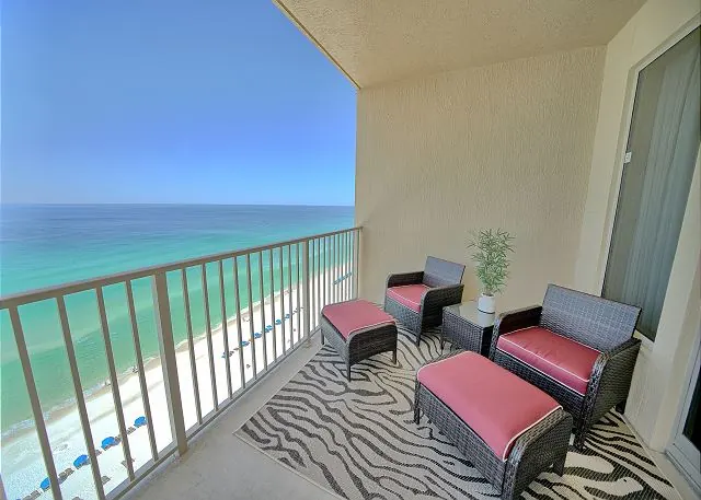 Red-cushioned loungers on a Gulf-front balcony with the Gulf of Mexico beyond