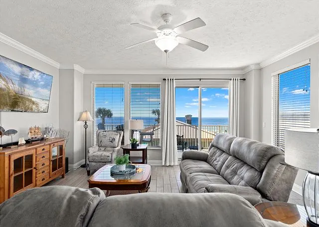 Beachfront condo living room with sofas facing sliding glass doors to the balcony and the Gulf