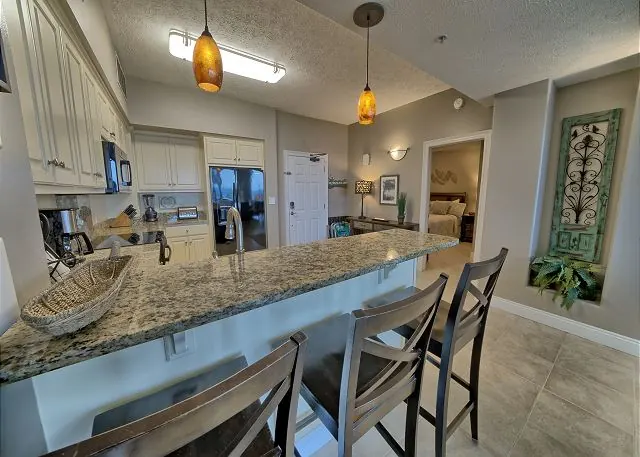 Condo kitchen with a granite breakfast bar and bar stools