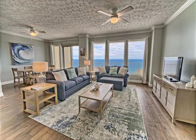 Living room with sofas and an ocean view through the balcony doors in a Panama City Beach condo