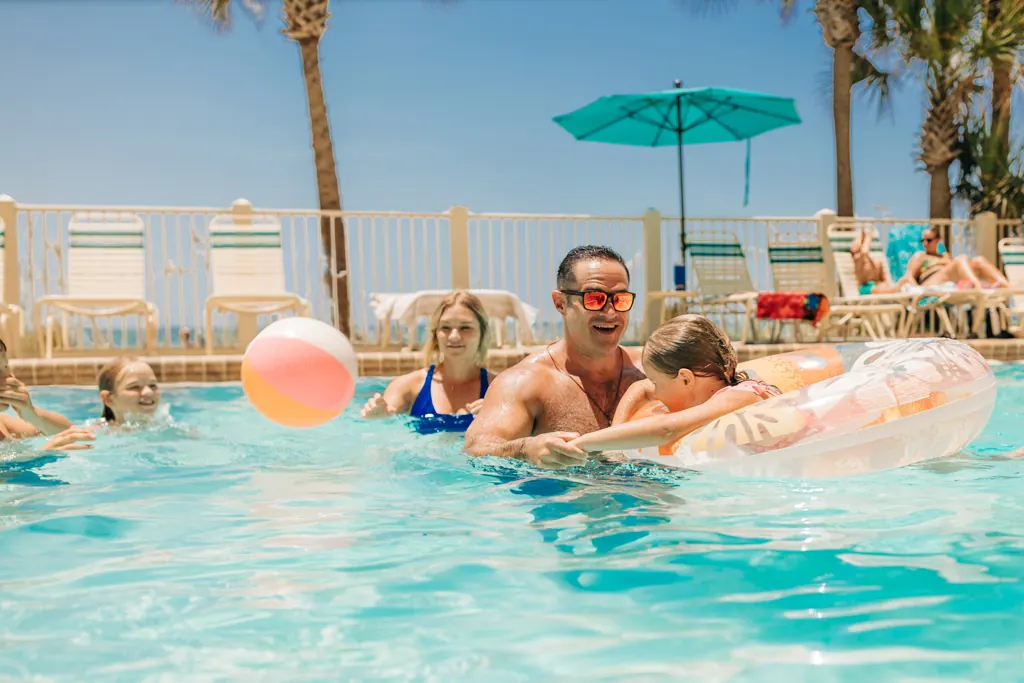 Family relaxing on floats in the Gulf Crest pool