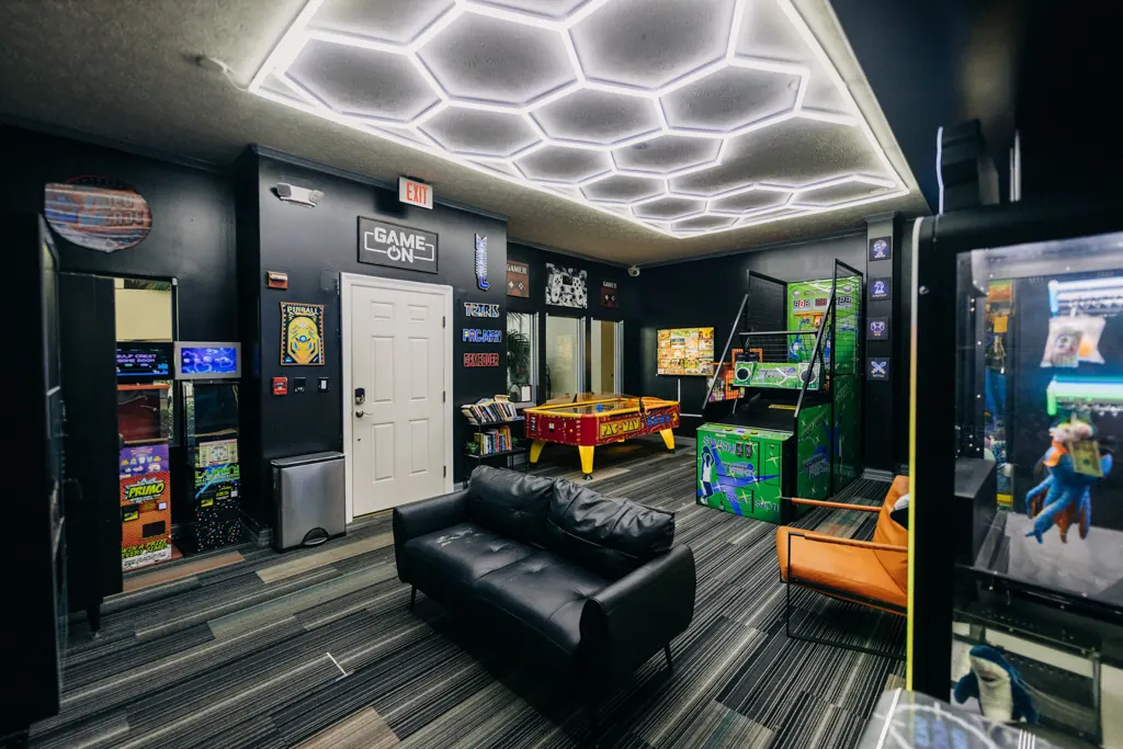 Game room lounge with a pool table and arcade games