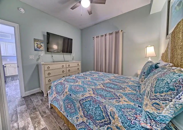 Guest bedroom with patterned bedding and a balcony door in a Gulf Crest condo