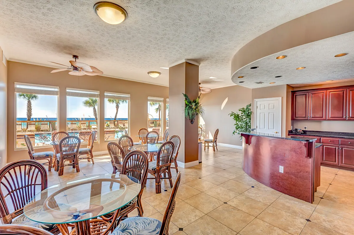 Common area with a kitchen, bar seating and tables