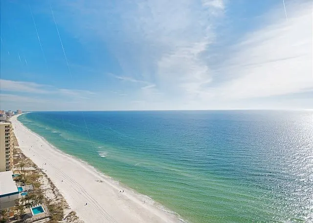 High-floor view of the white-sand beach curving along the emerald Gulf in Panama City Beach