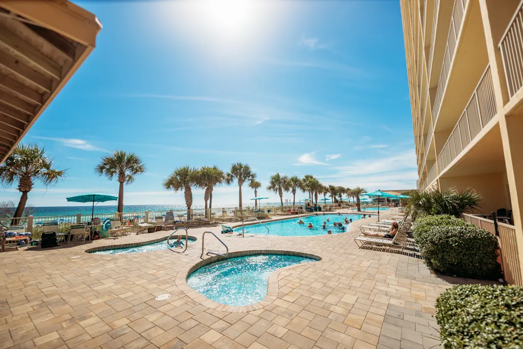 Hot tub and pool deck with palms on a sunny day at Gulf Crest