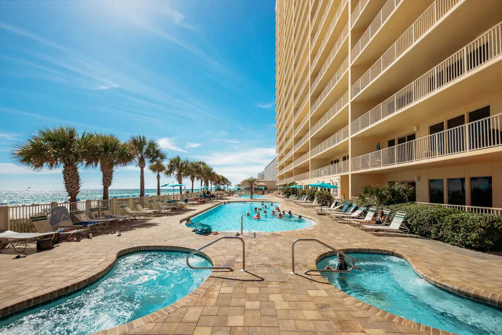 Two hot tubs and a pool beside the Gulf Crest Condominiums tower