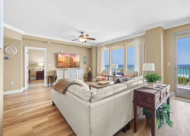 Open living and dining area with a white sofa and Gulf-view windows in a Gulf Crest condo