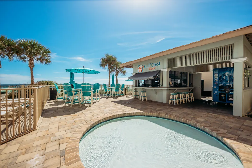 Pool deck and bar with palm trees on a clear day