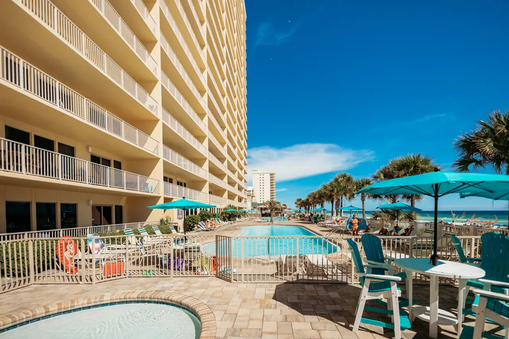 Pool deck with umbrellas stretching along the Gulf Crest tower