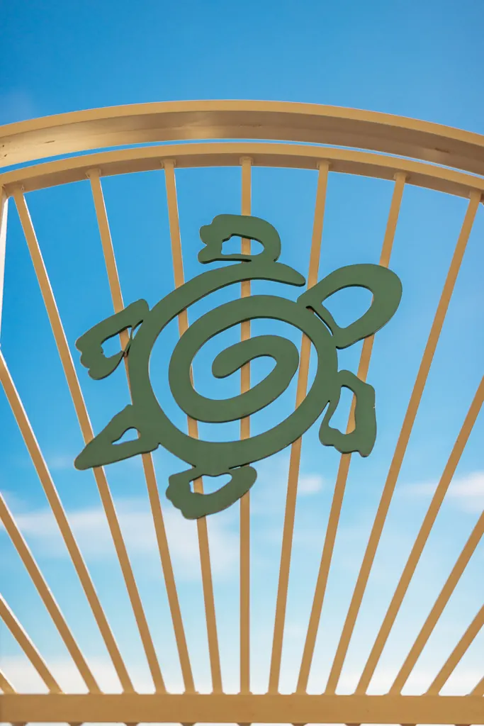 Detail of the sea turtle emblem on the beach gate