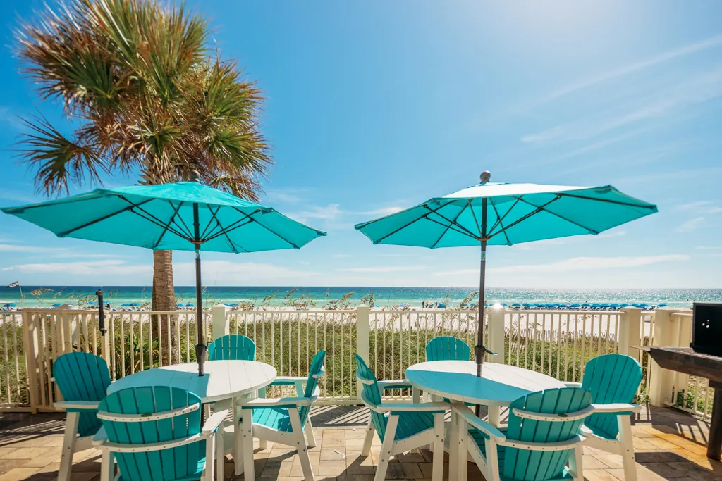 Teal umbrellas and tables on the deck overlooking the Gulf of Mexico