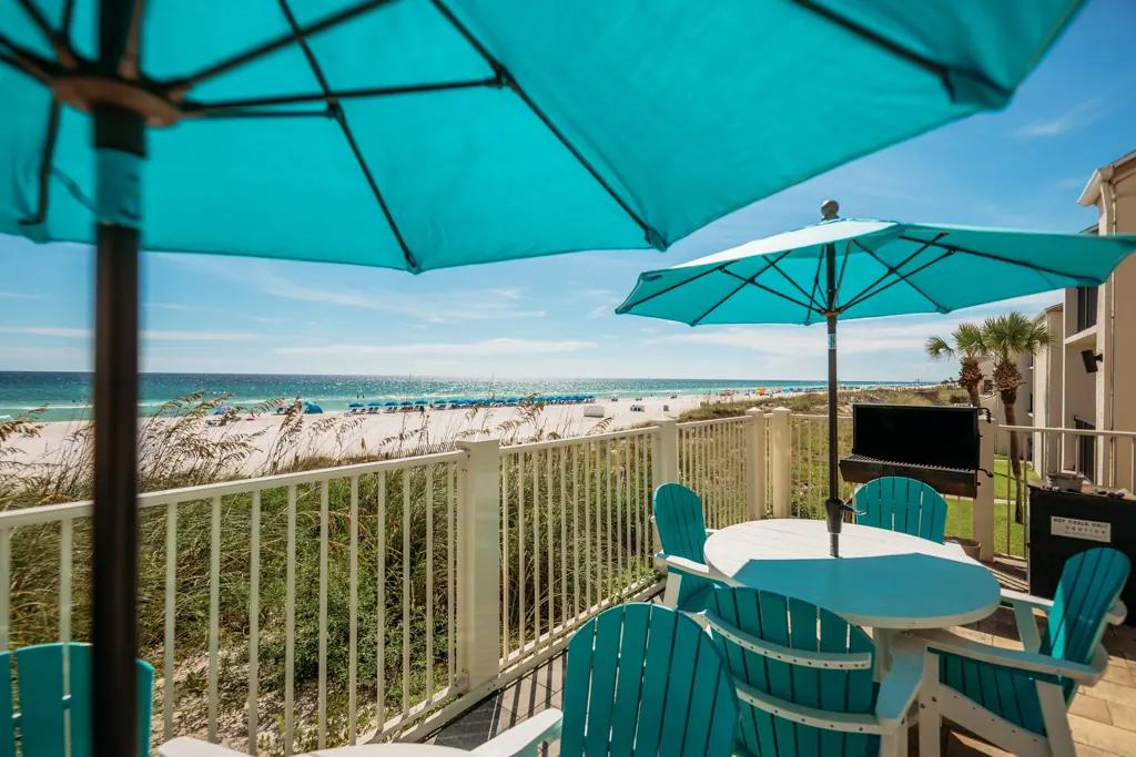 Umbrella tables at the deck railing overlooking the beach and Gulf